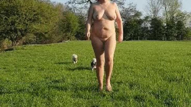 Fat blonde walking nude in a field
